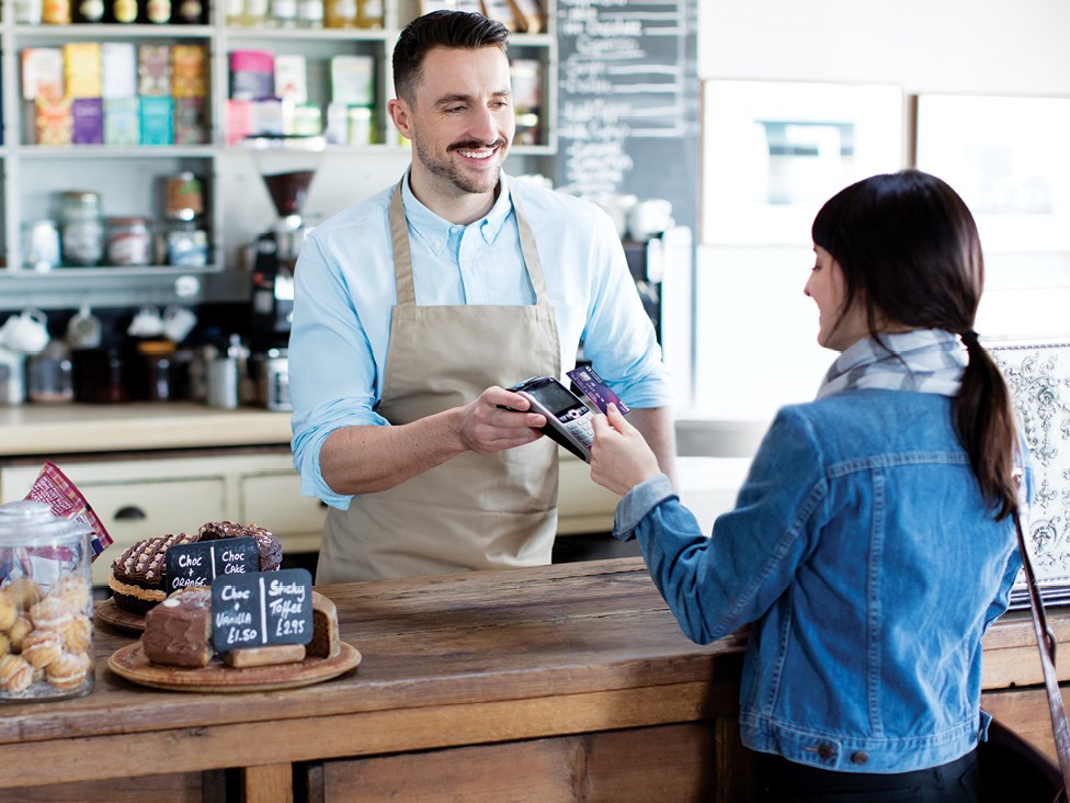 Girl using debit card in coffee shop